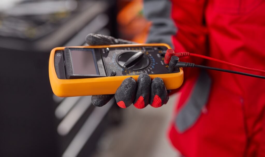 Male mechanic checking voltage of battery